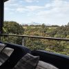 Lanai with Resource Furniture Flex outdoor sofa, taro plant, stainless cable and ipe railing by Hawaii Off-Grid and view of the west maui mountains.